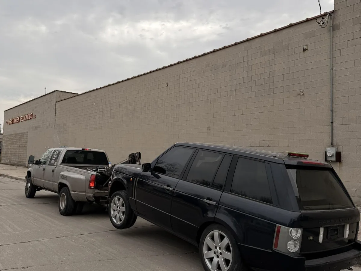 Black SUV staged behind a tow truck for pickup