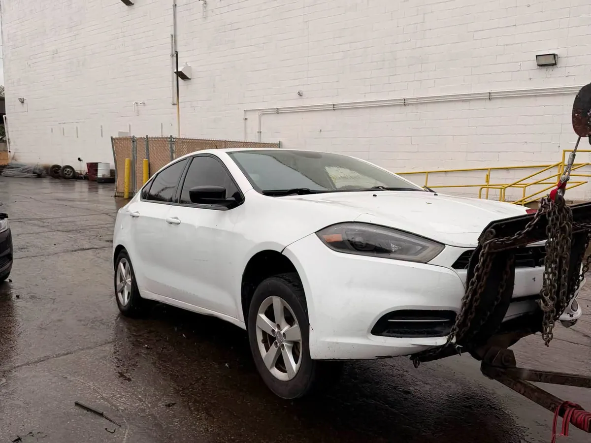 White sedan chained down on a flatbed tow truck