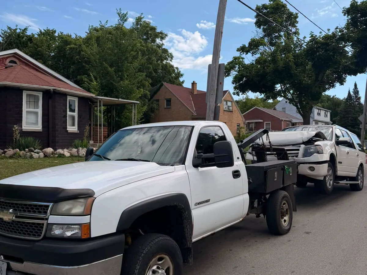 Damaged white SUV loaded on a flatbed tow truck
