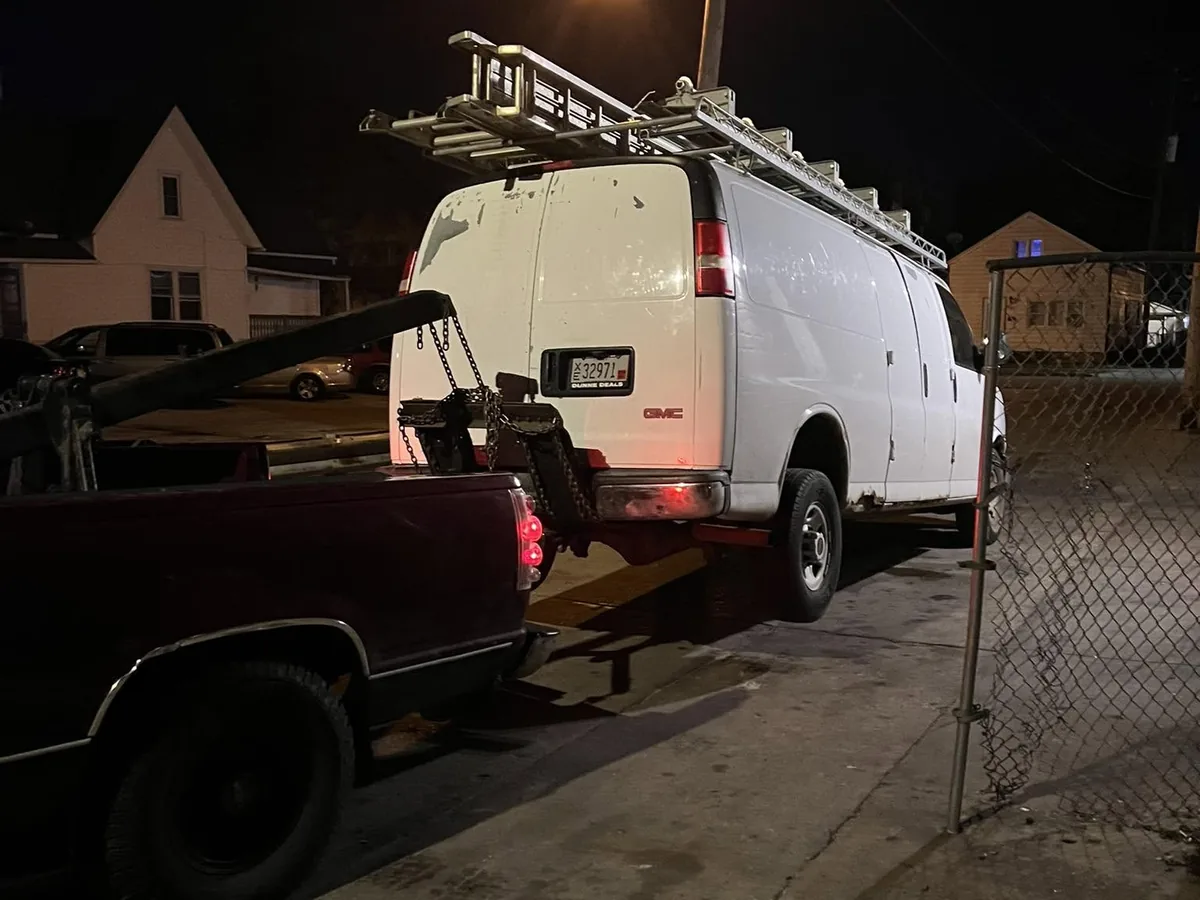 White work van with a ladder rack loaded on a flatbed