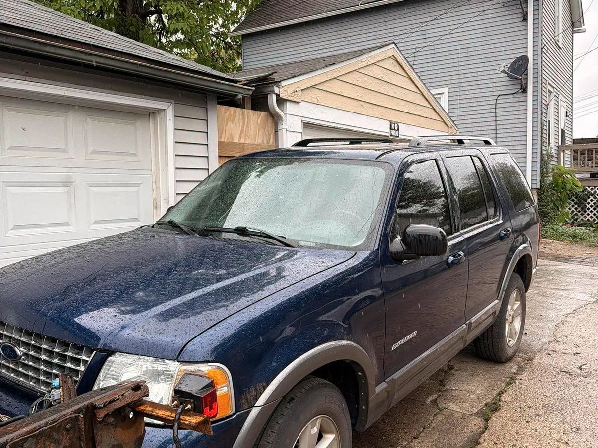 Blue SUV raised on a tow truck wheel lift